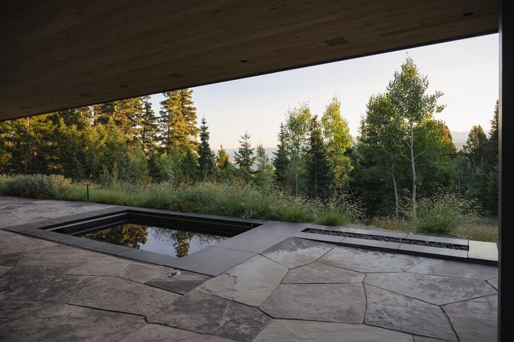 Reflecting pool and flagstone terrace opening to aspens at dusk